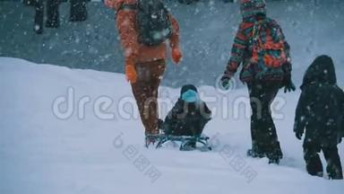 <strong>一家人的</strong>爸爸，妈妈，小儿子和女儿骑着雪橇在松树林里下雪。 慢动作